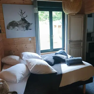 Un ou plusieurs lits dans un hébergement de l'établissement Chalet Bois le Havre du sotrè Gérardmer Sauna panoramique jacuzzi 14 personnes et 1 bébé