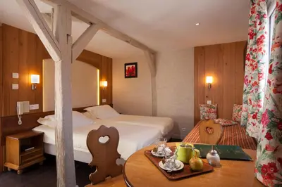 Un ou plusieurs lits dans un hébergement de l'établissement Logis Hôtel de la Tour
