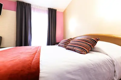 Un ou plusieurs lits dans un hébergement de l'établissement Hotel Cheval De Bronze