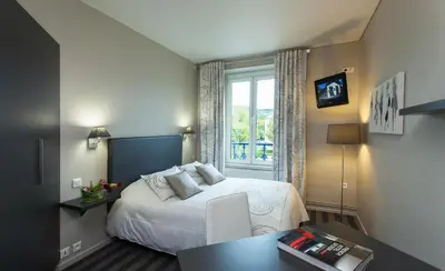 Un ou plusieurs lits dans un hébergement de l'établissement Hotel Restaurant Les Capucins