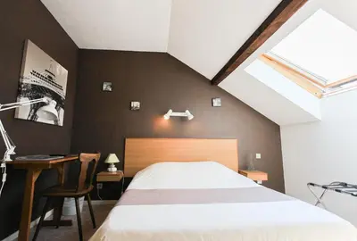 Un ou plusieurs lits dans un hébergement de l'établissement Hotel Restaurant De La Poste Mulhouse Ottmarsheim
