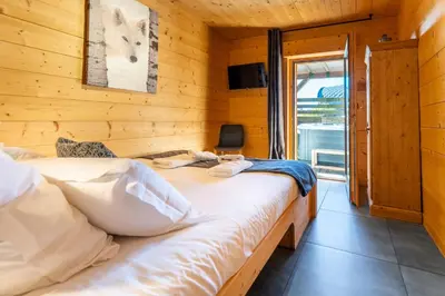 Un ou plusieurs lits dans un hébergement de l'établissement Chalet des Cîmes, chaleureux avec jacuzzi et sauna